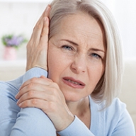 A woman holding her head in pain